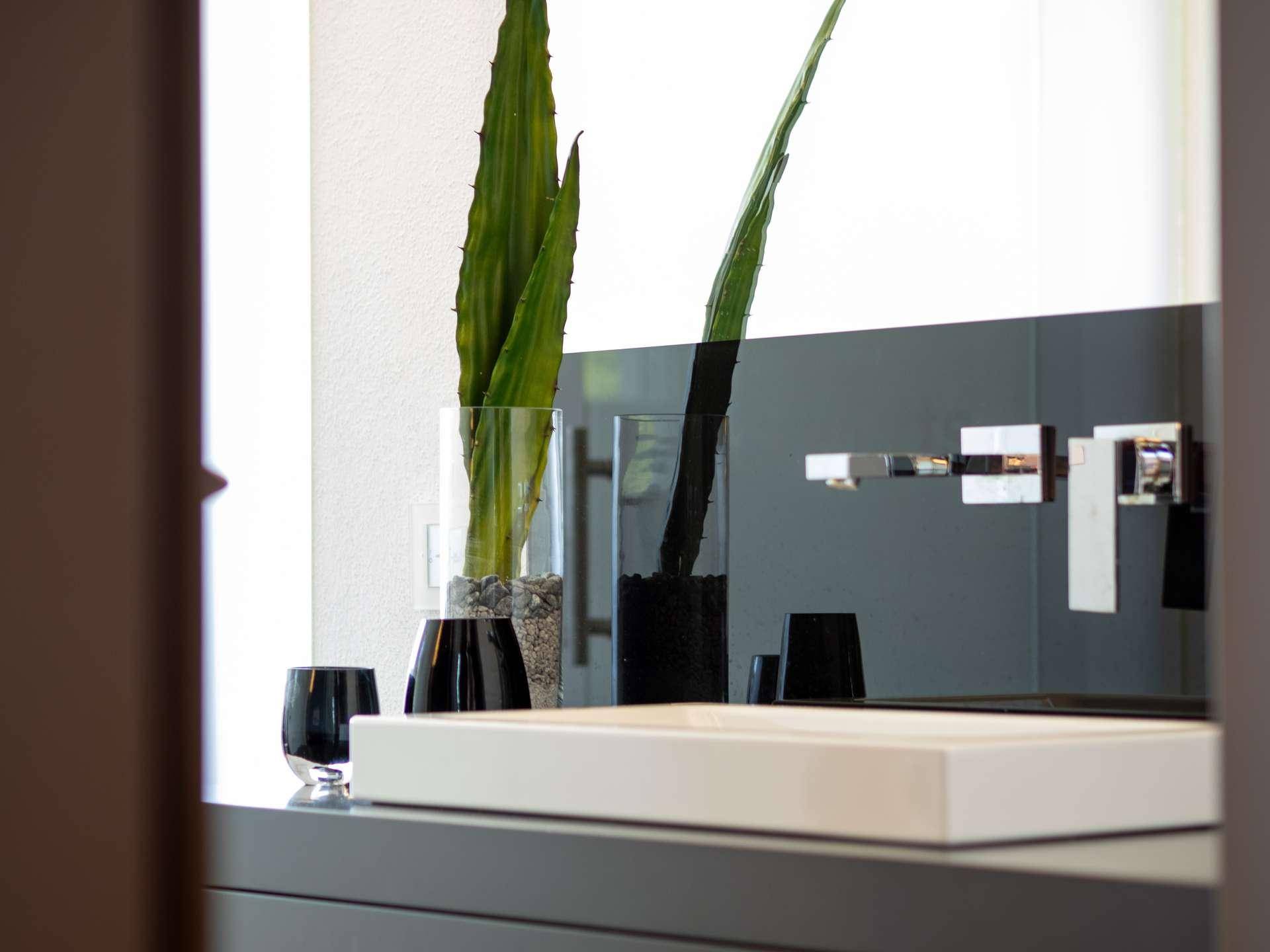 Detailaufnahme eines modernen Waschbeckens mit stilvoller Armatur und minimalistischer Dekoration.