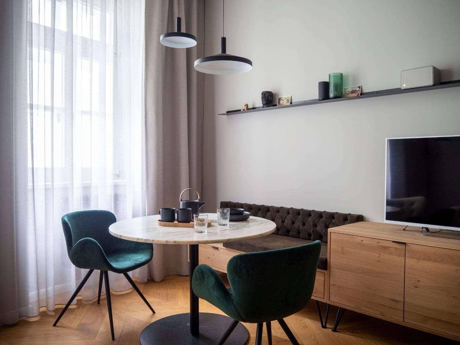 Helles Wohn- und Esszimmer mit modernem Mobiliar, Holzboden und großen Fenstern.
