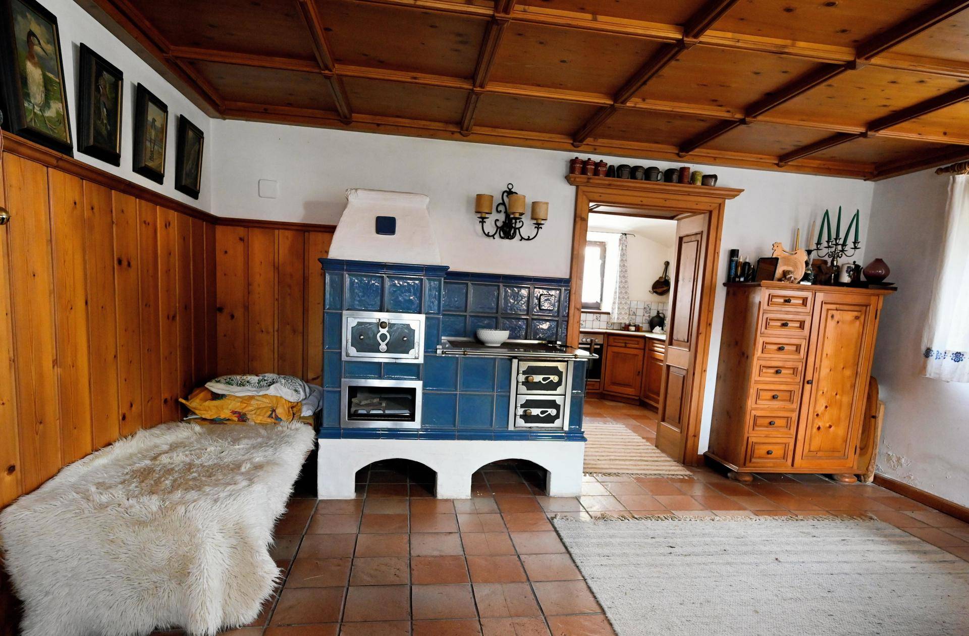 Traditionelles Wohnzimmer mit blauem Kachelofen, Holztäfelung und rustikalem Charme.