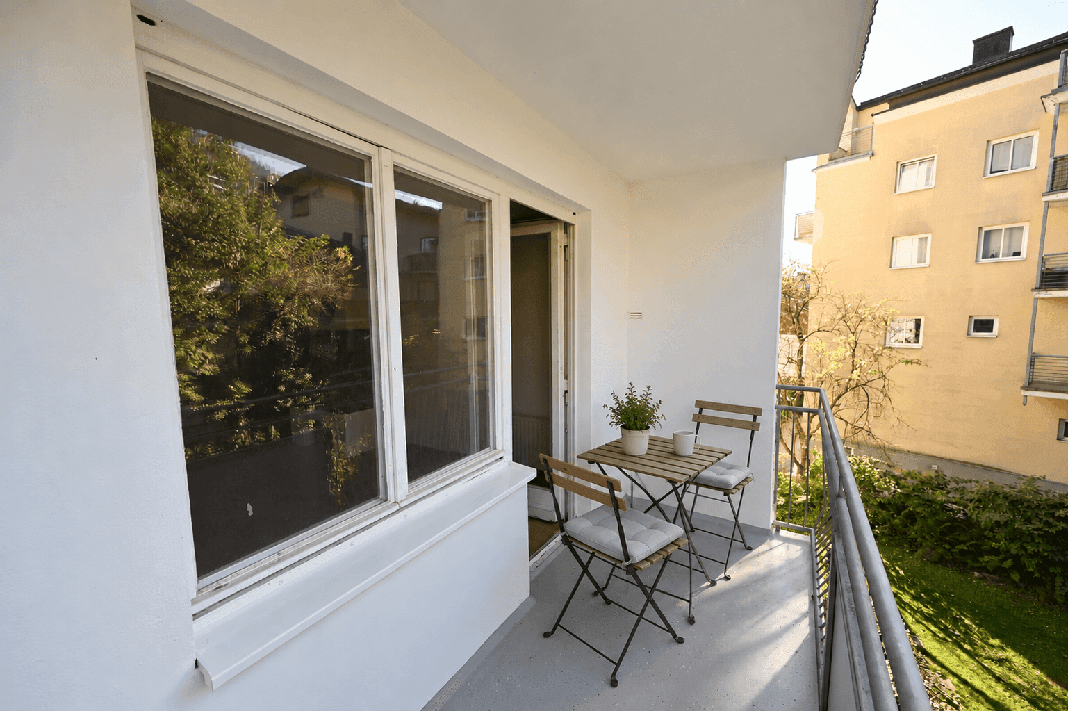 Gemütlicher Balkon mit Sitzgelegenheiten und Pflanzen, ideal für entspannte Stunden im Freien.