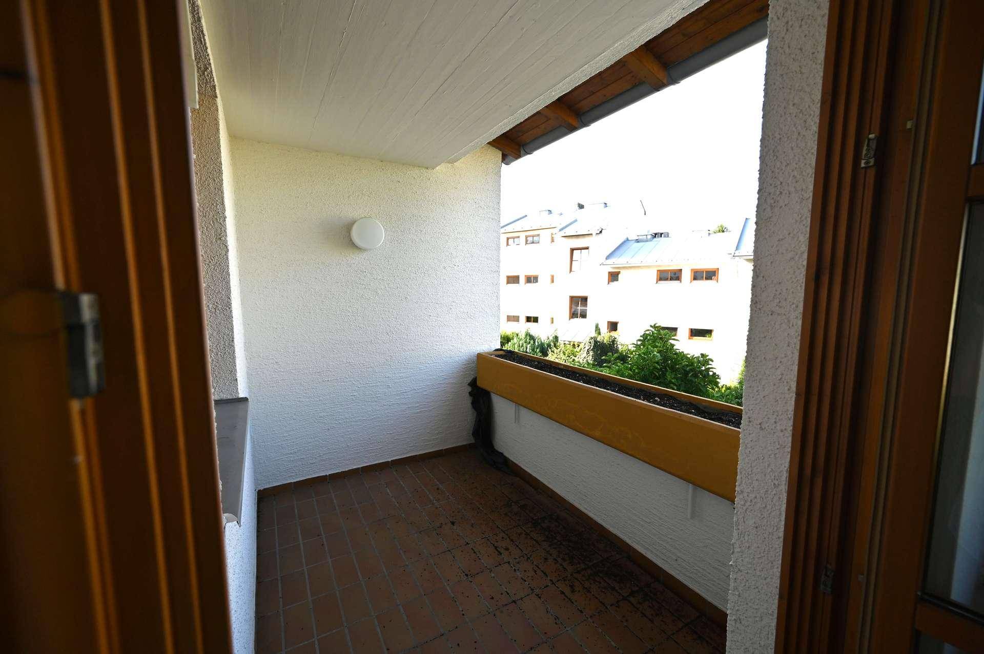 Kleiner Balkon mit Fliesenboden und Blick auf die umliegenden Gebäude.
