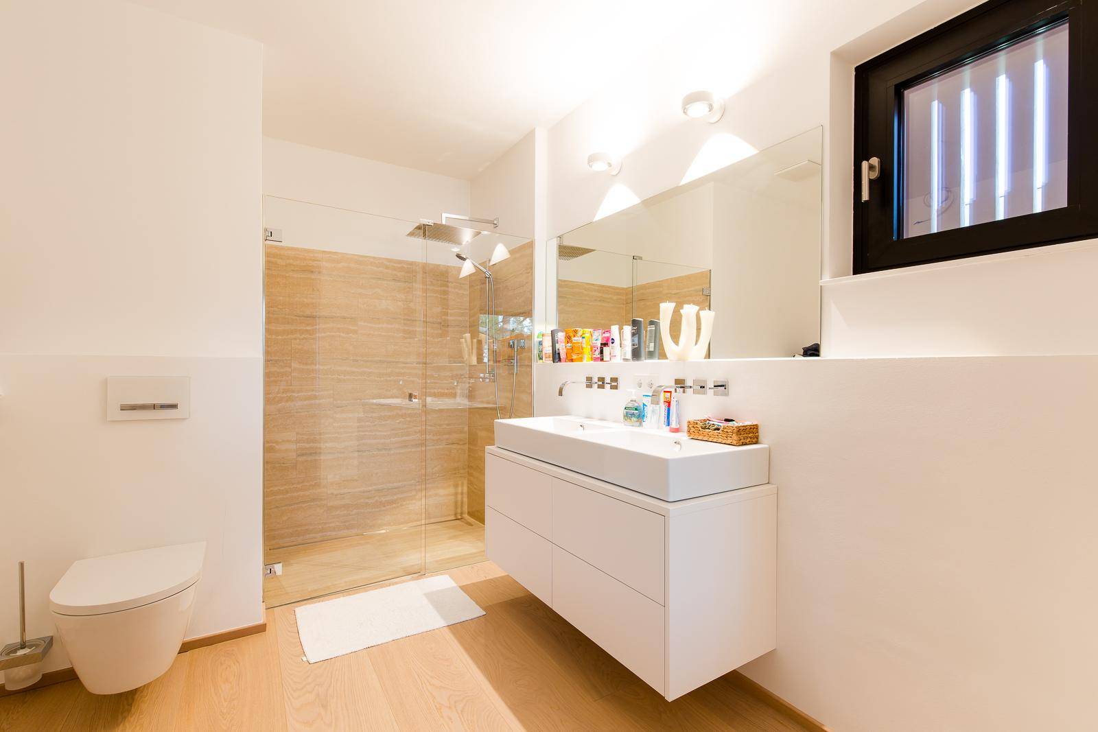 Modernes Badezimmer mit großer begehbarer Dusche, Doppelwaschbecken und Fenster für Tageslicht.