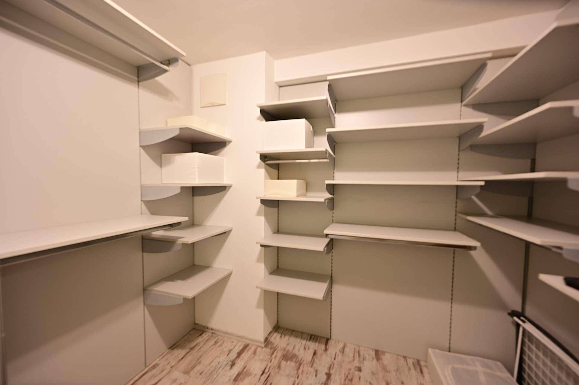 Geräumiger begehbarer Kleiderschrank mit vielen Regalen für optimale Organisation.