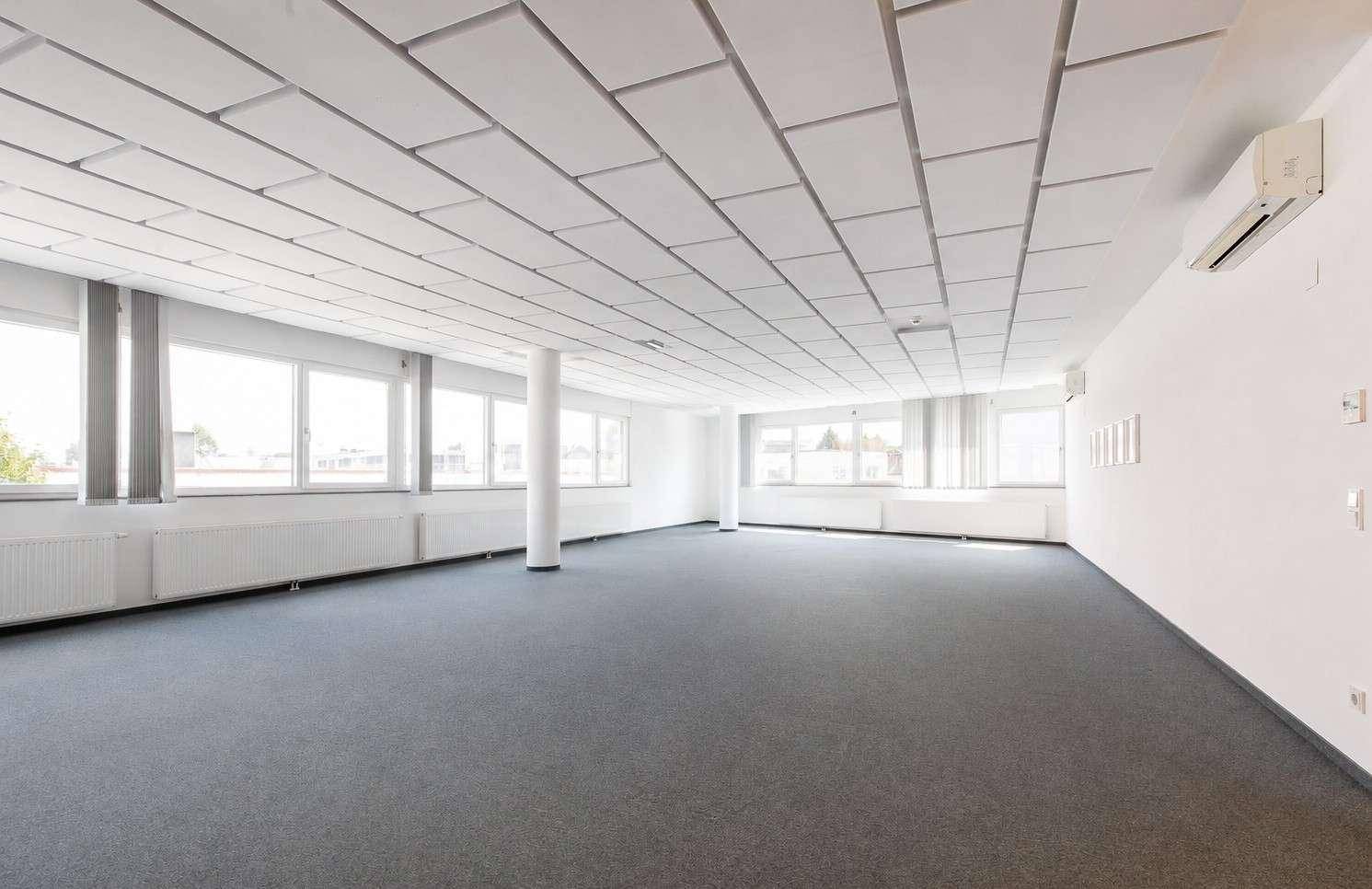 Großes, helles Büro mit Klimaanlage, vielen Fenstern und Teppichboden für angenehmes Arbeiten.