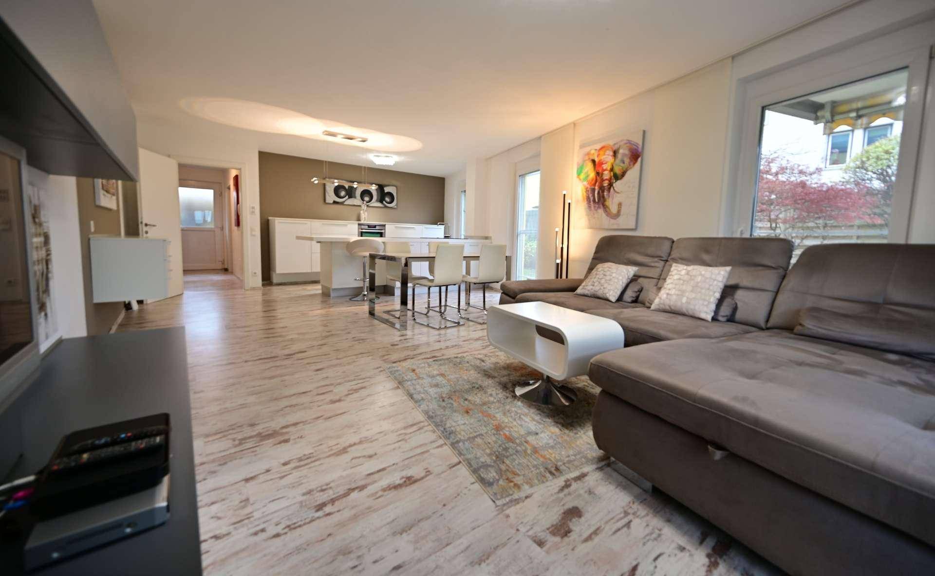Gemütlicher Wohnbereich mit großem Sofa und Blick auf die offene Küche.