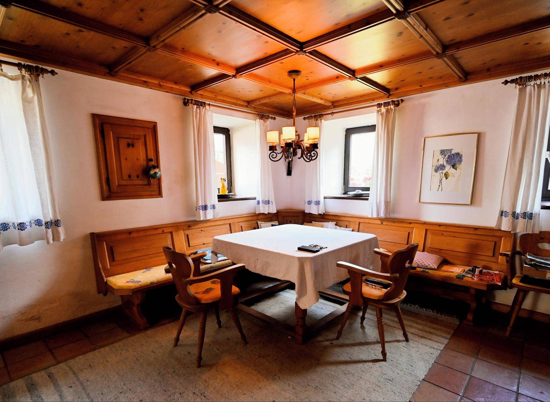Gemütlicher Essbereich mit Holztäfelung, Kassettendecke und traditionellen Eckbänken.