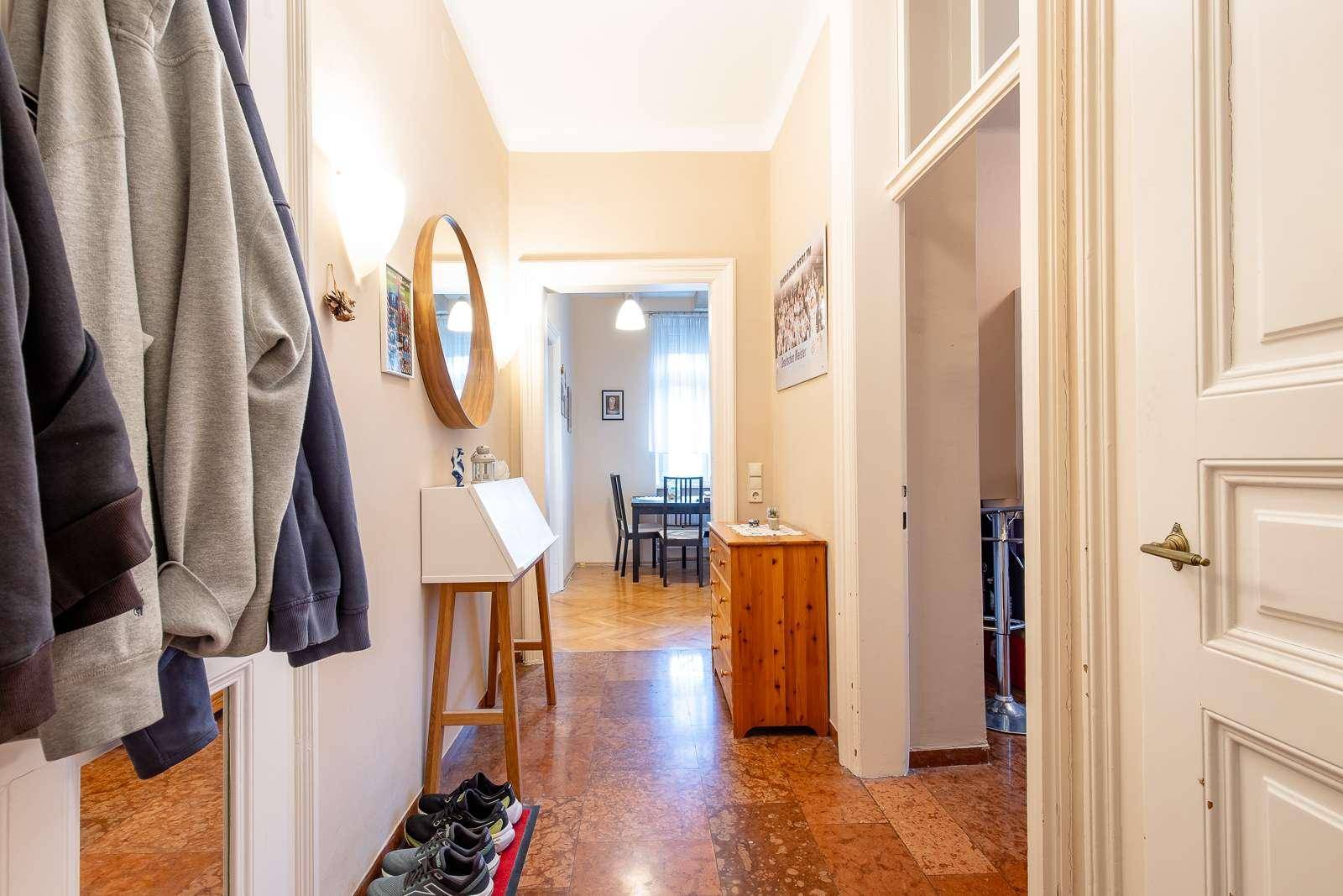 Heller Flur mit Terrakotta-Fliesenboden, Garderobe und Blick in den Essbereich.