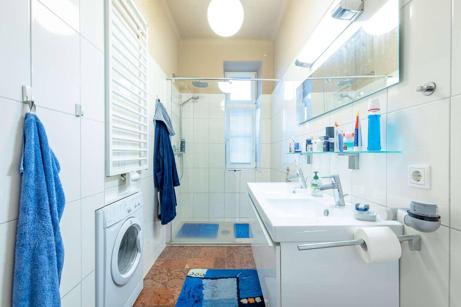 Modernes Badezimmer mit Dusche, Doppelwaschbecken und Waschmaschine.