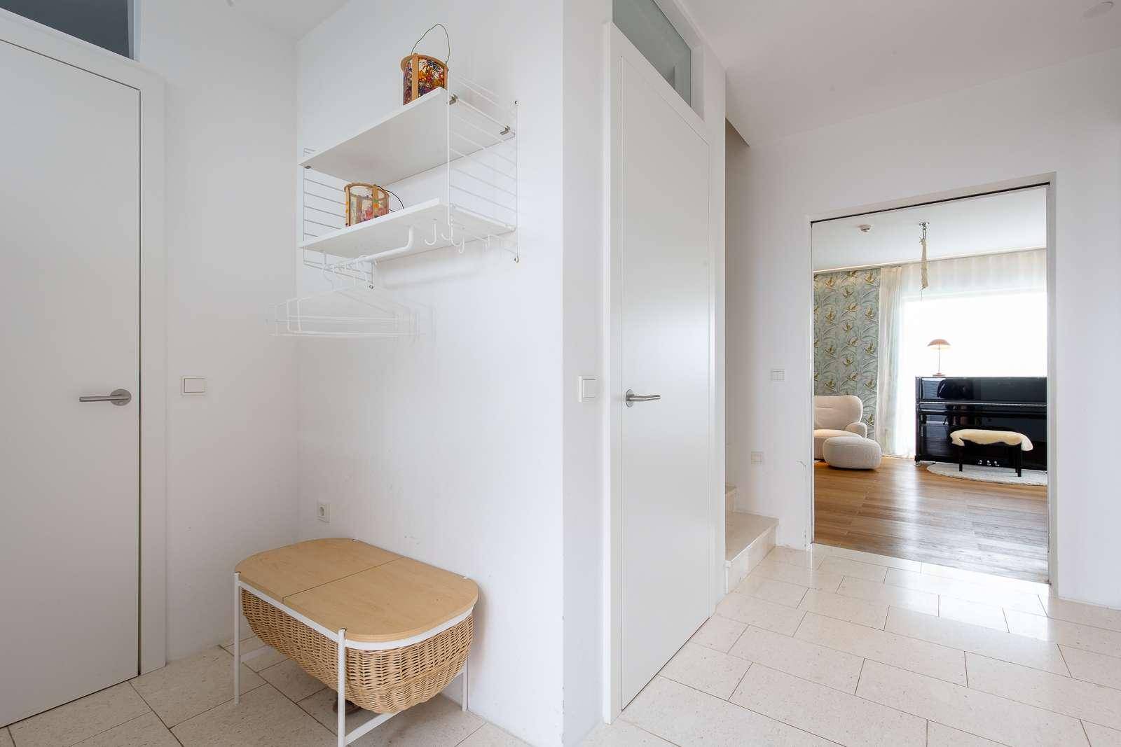 Eingangsbereich mit Garderobe, Sitzbank und Blick in den Wohnbereich.