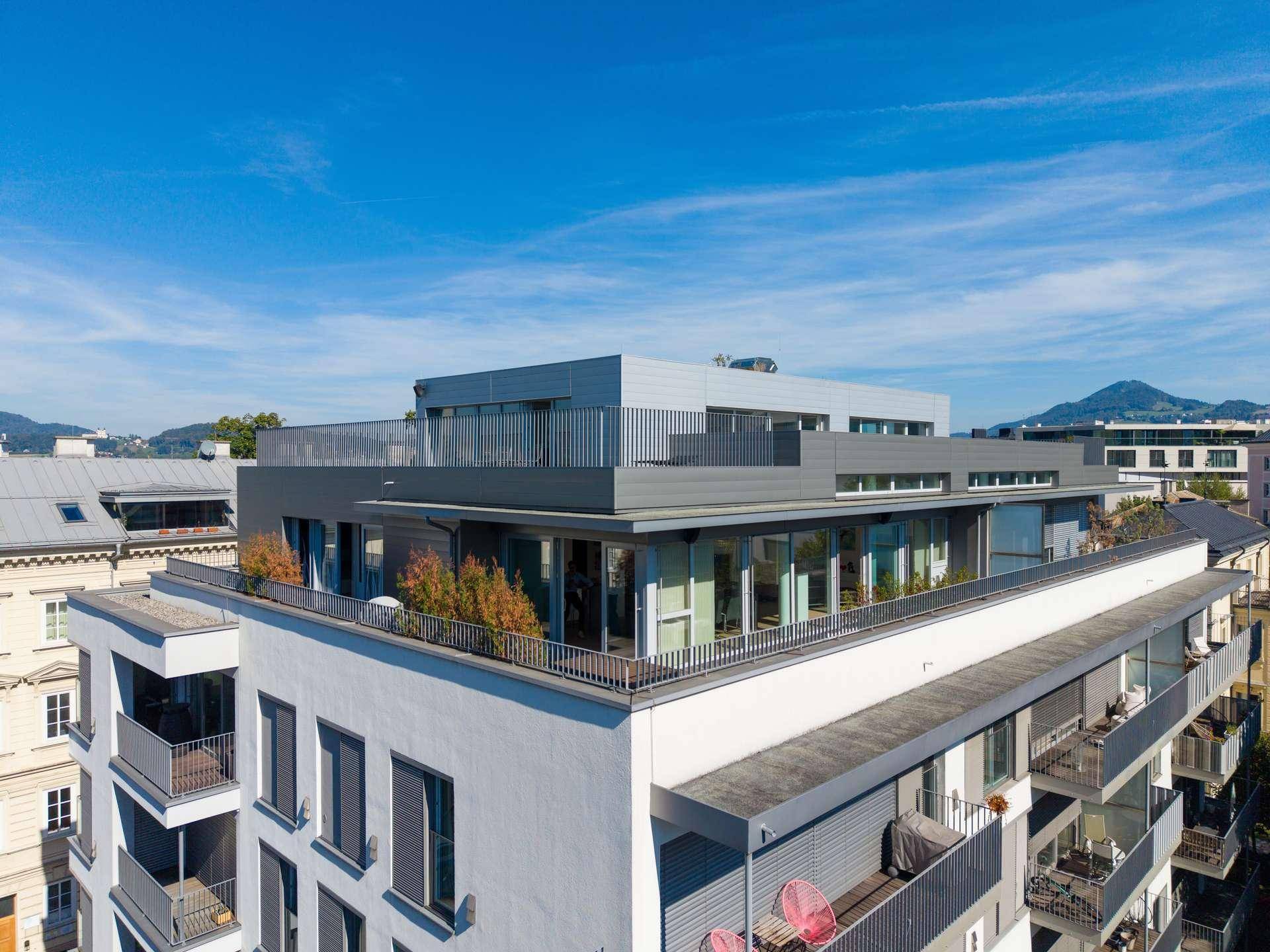 Panoramablick auf ein modernes Wohngebäude mit mehreren Terrassen und Balkonen.