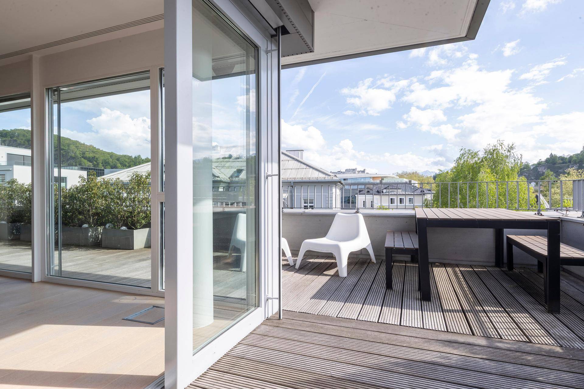 Geräumige Dachterrasse mit Holzboden, Sitzgelegenheiten und weitem Ausblick.