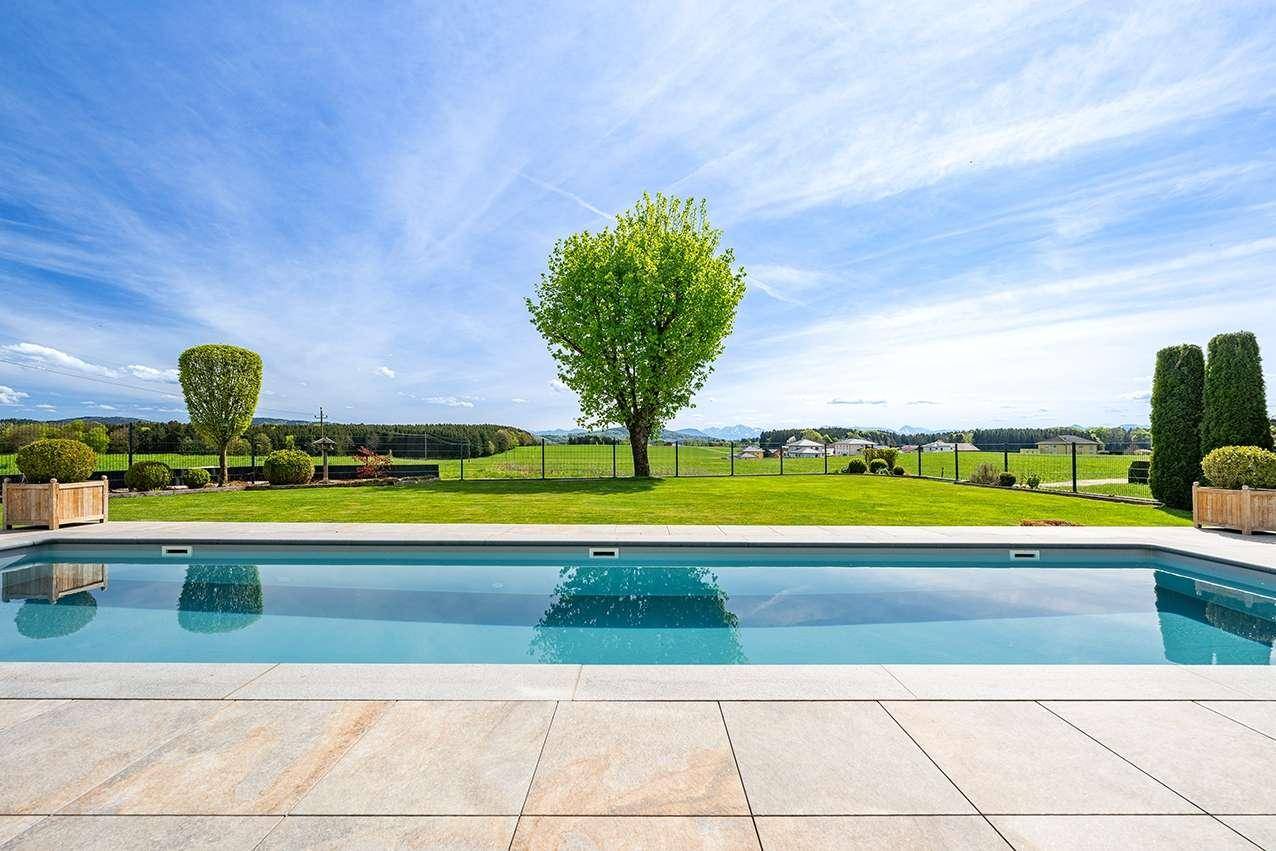 Großzügiger Swimmingpool mit gepflegter Rasenfläche und weitem Blick auf die grüne Landschaft.