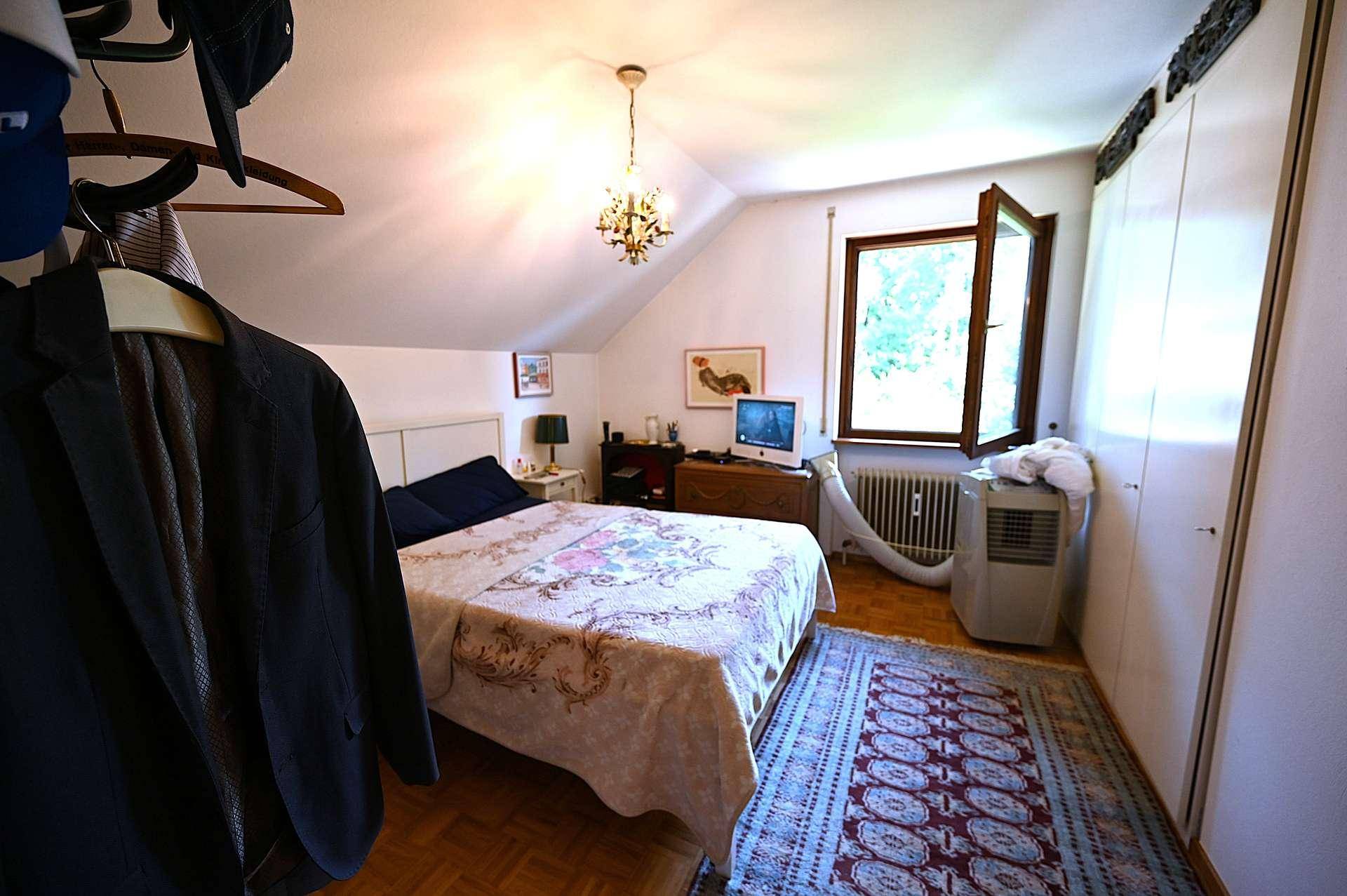 Gemütliches Schlafzimmer mit Doppelbett, Kleiderschrank, Dachschräge und Fenster.