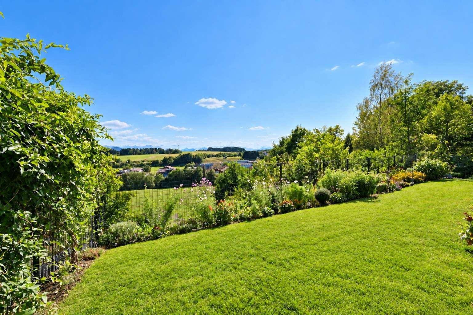 Weitläufiger Garten mit üppigem Grün und einem Panoramablick über die sanfte Hügellandschaft.