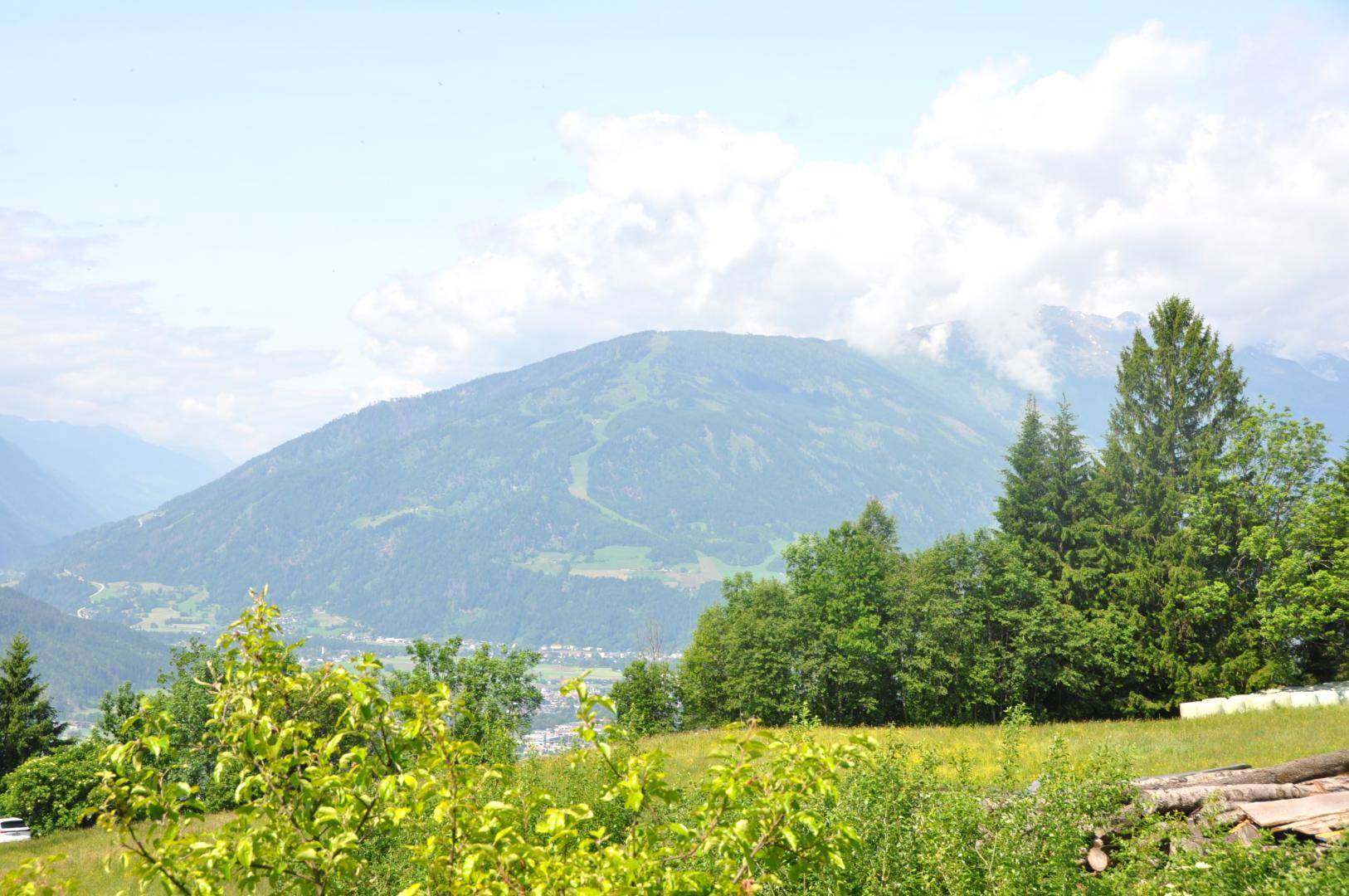 Atemberaubender Blick auf majestätische Berge, umgeben von üppiger grüner Vegetation unter blauem Himmel.