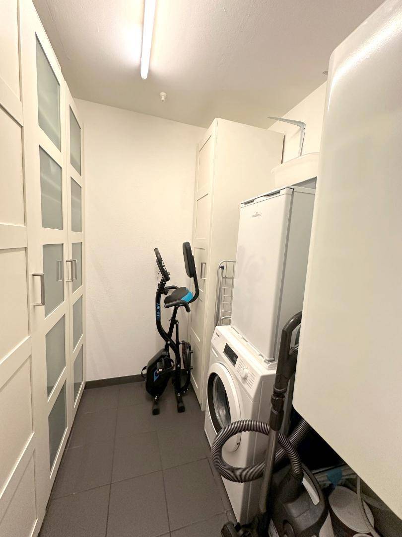 Praktischer Hauswirtschaftsraum mit Waschmaschine, Trockner und integrierten Schränken.