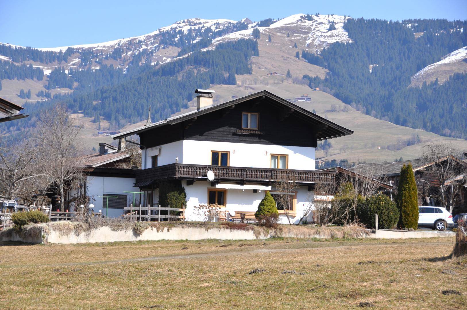 Traditionelles Haus im alpinen Stil mit Holzbalkon und beeindruckendem Bergblick.