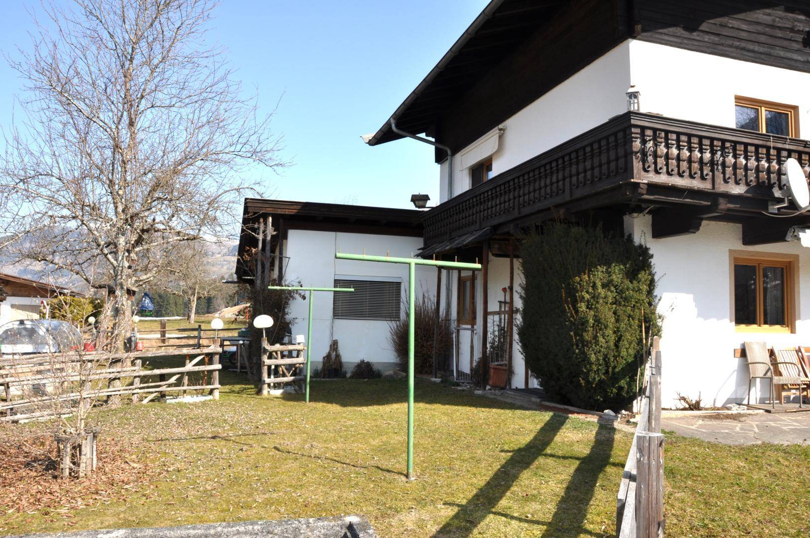 Gepflegter Gartenbereich neben dem Haus mit Rasenfläche und Wäscheleine.