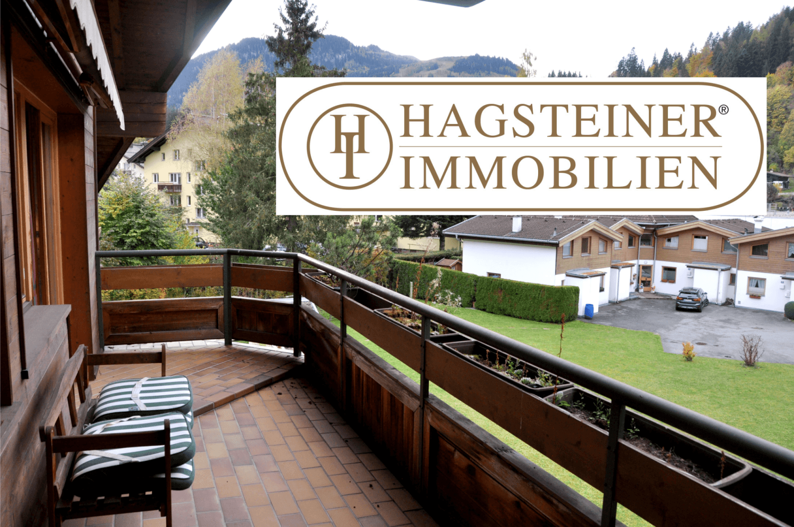 Geräumiger Balkon mit Fliesenboden und Holzbalkonbrüstung, bietet Blick auf die umliegende Landschaft.