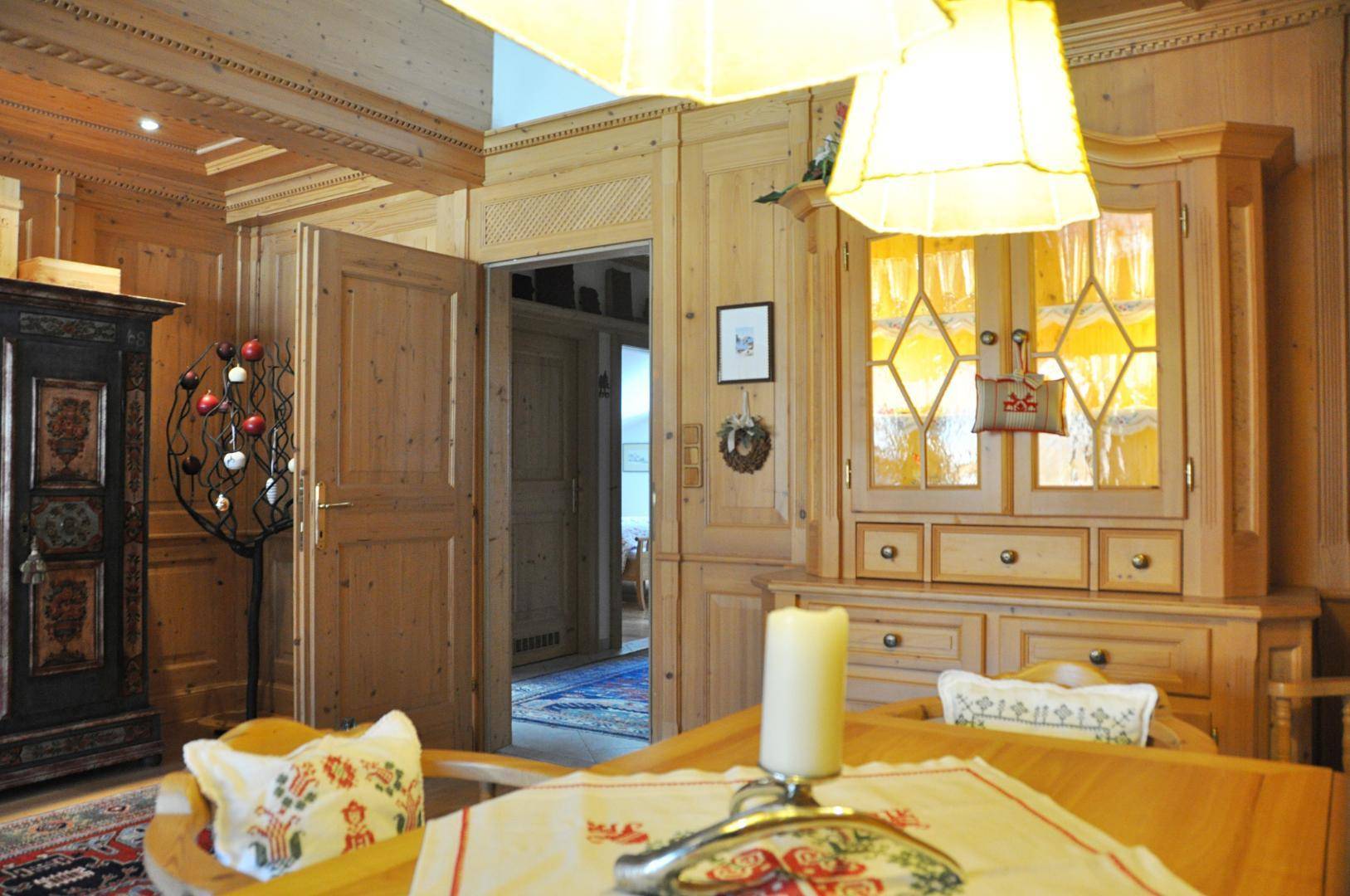 Traditioneller Essbereich mit Holzmöbeln und aufwendiger Holzvertäfelung, führt zu einem weiteren Raum.