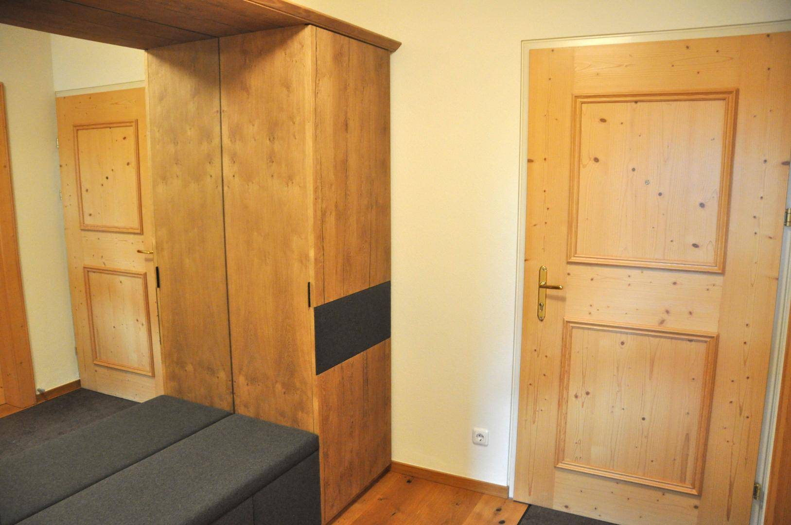Flur oder Übergangsbereich mit Holzschrank und traditionellen Holztüren.