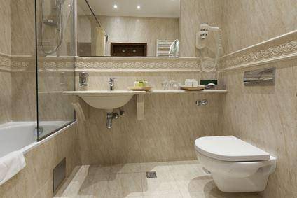 Gefliestes Badezimmer mit Badewanne, Duschabtrennung und wandhängendem WC.