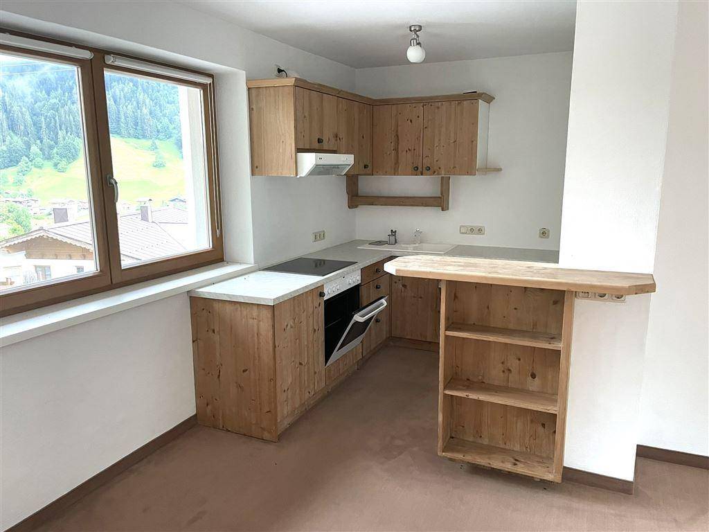 Gemütliche Küche im Landhausstil mit Holzeinbauten, integriertem Ofen und Bergblick.