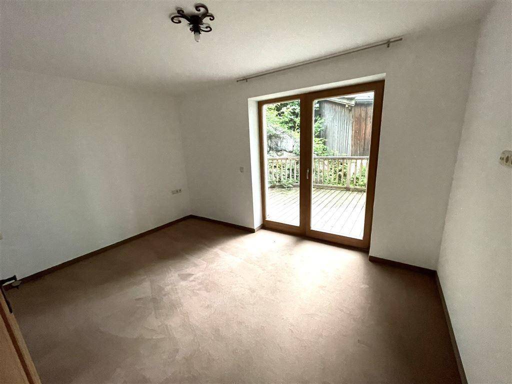 Schlafzimmer mit direktem Zugang zur Holzterrasse, ideal für frische Luft am Morgen.