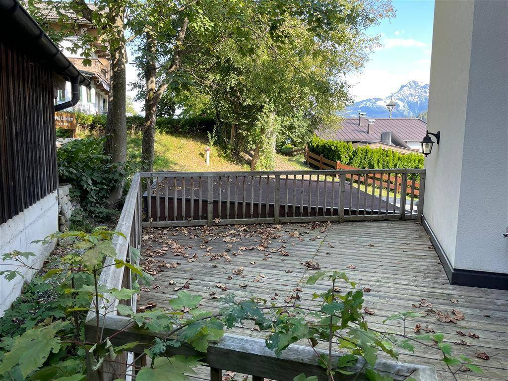 Geräumige Holzterrasse mit Blick auf die umliegende Natur und entfernte Berge.