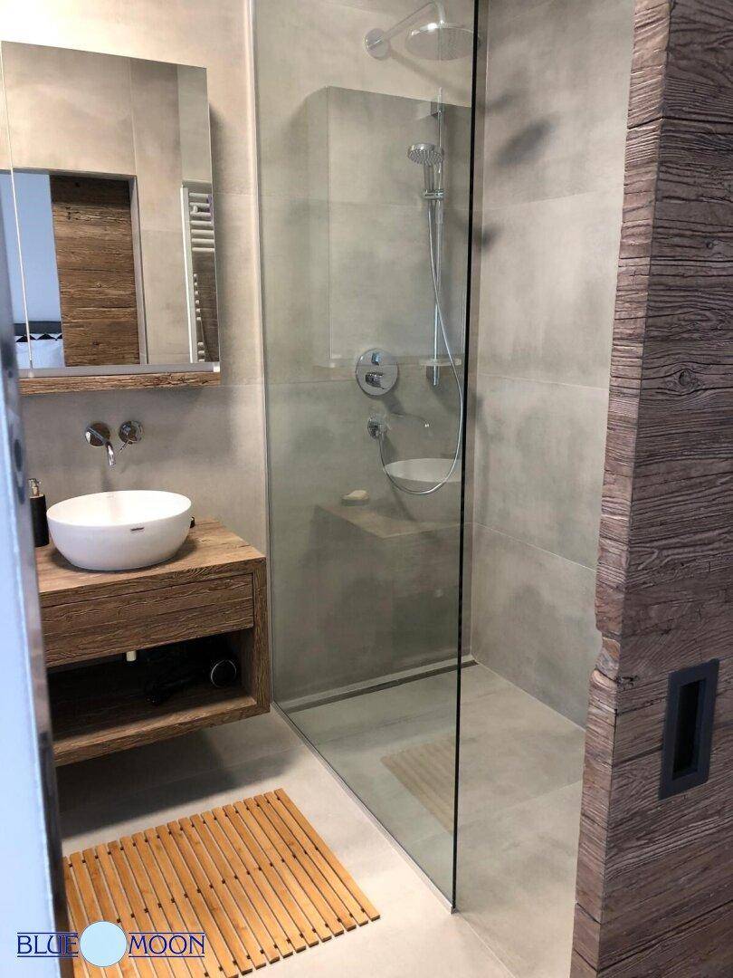 Modernes Badezimmer mit begehbarer Dusche, Aufsatzwaschbecken und Holzunterschrank.