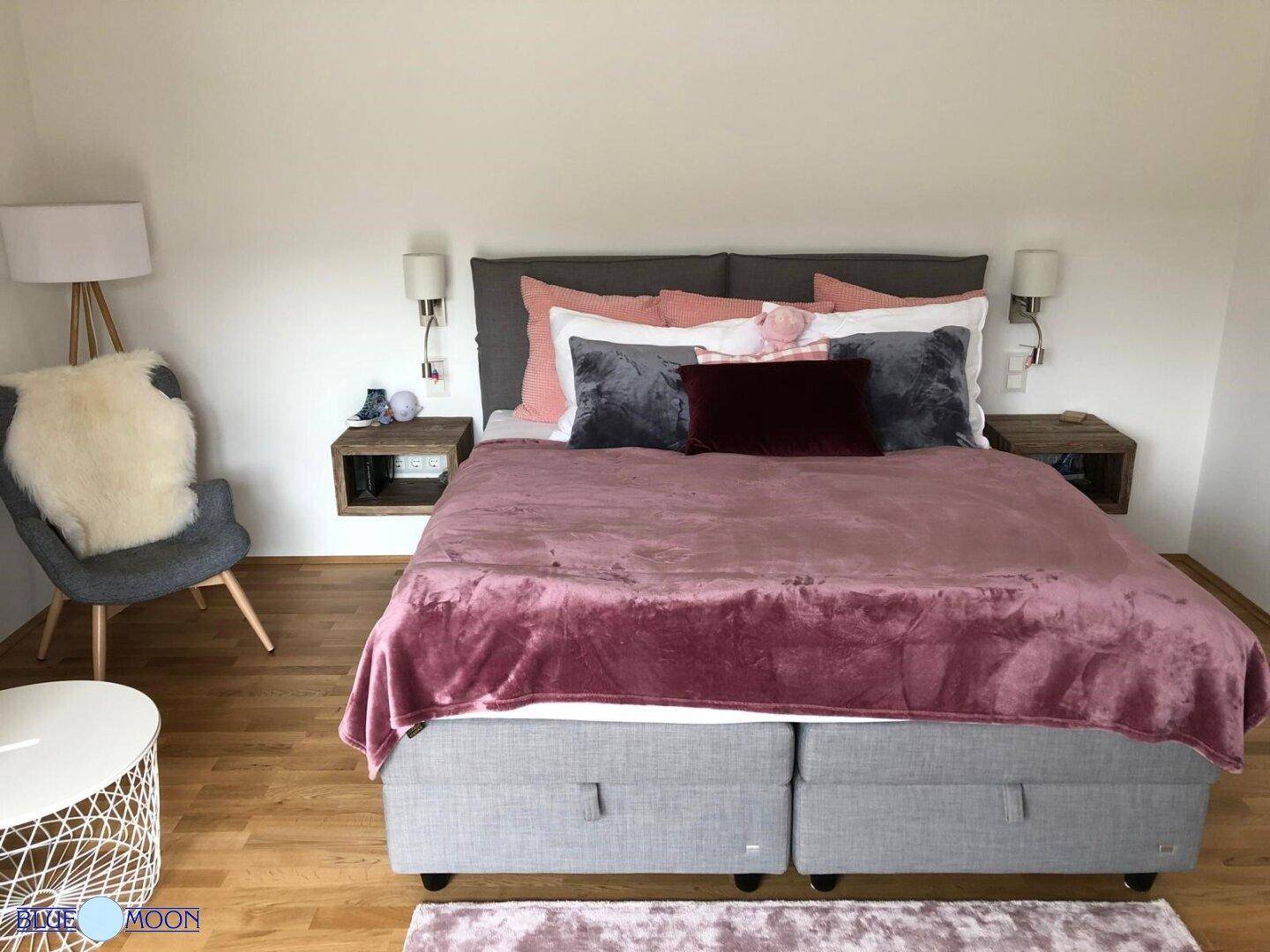 Gemütliches Schlafzimmer mit Doppelbett, Holzboden und moderner Einrichtung.