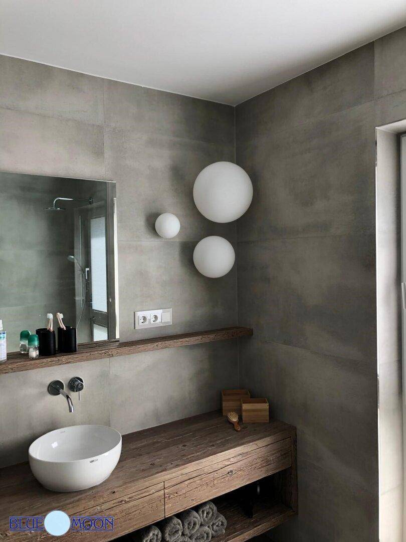 Modernes Badezimmer mit weißem Aufsatzwaschbecken, Holzablage und großem Spiegel.
