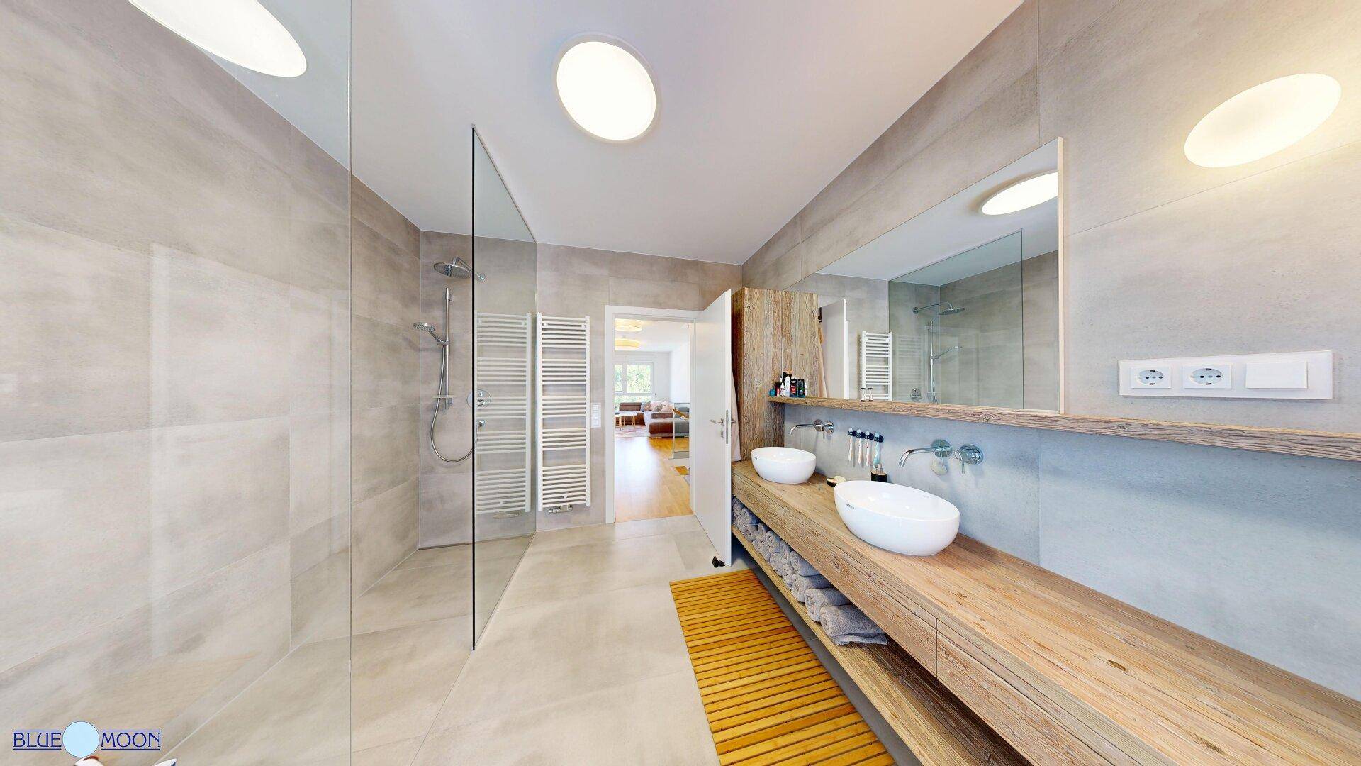 Großes modernes Badezimmer mit begehbarer Dusche, Doppelwaschbecken und Fliesenboden.