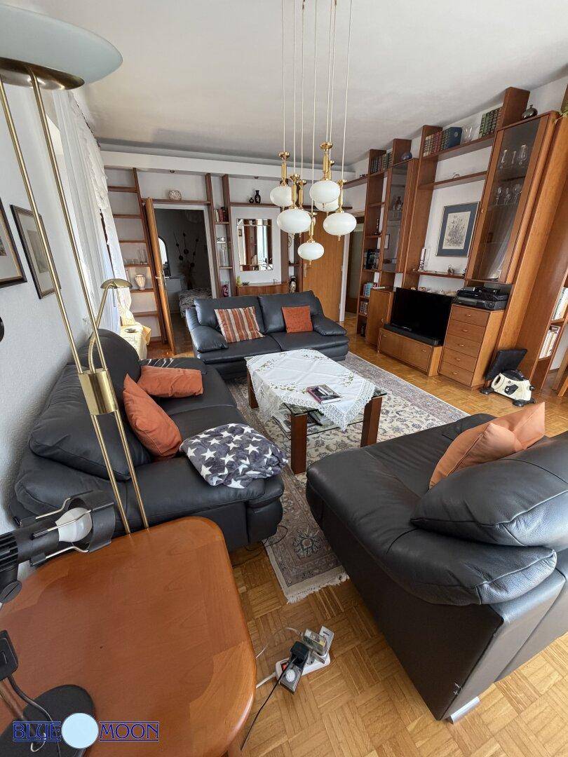 Heller Wohn- und Essbereich mit Ledersofas, Holzelementen und einem einladenden Ambiente.