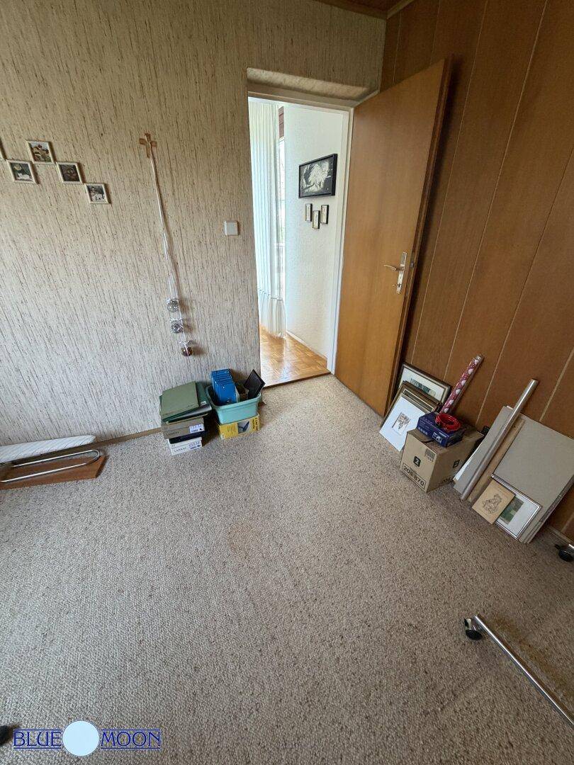 Arbeitszimmer mit Teppichboden und Holzvertäfelung, bietet einen ruhigen Rückzugsort.