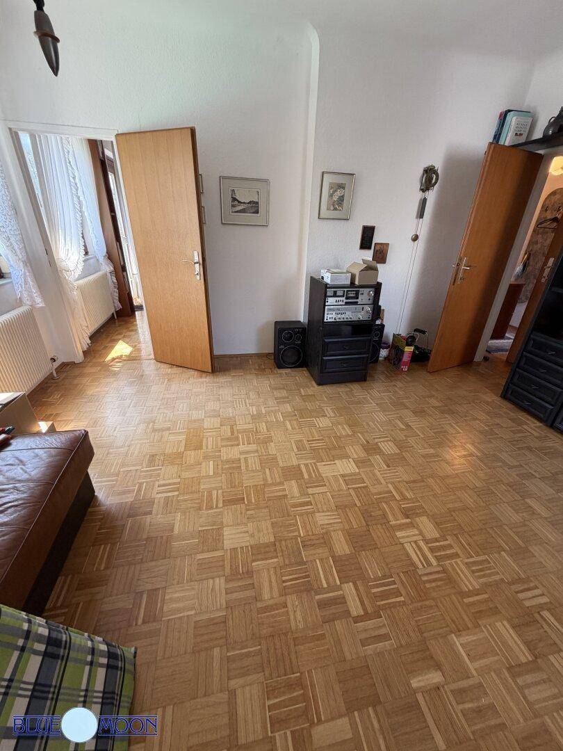 Heller Raum mit Parkettboden und Stereoanlage, bietet Platz für verschiedene Aktivitäten.