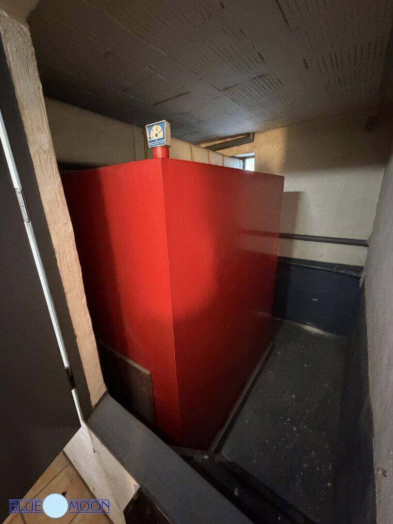 Kellerraum mit großem roten Tank, vermutlich für Heizöl, bietet Lagerfläche.