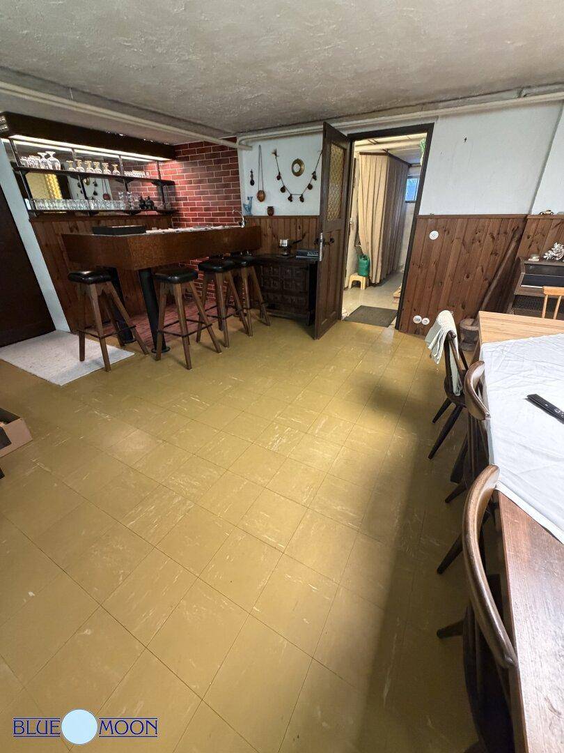 Gemütlicher Kellerraum mit Bar, Holzvertäfelung und Fliesenboden, ideal für gesellige Abende.