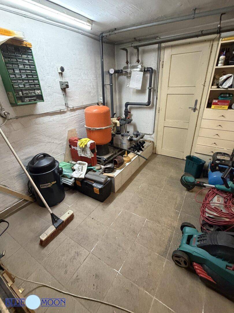 Praktischer Hauswirtschaftsraum im Keller mit technischen Installationen und Stauraum für Werkzeuge.