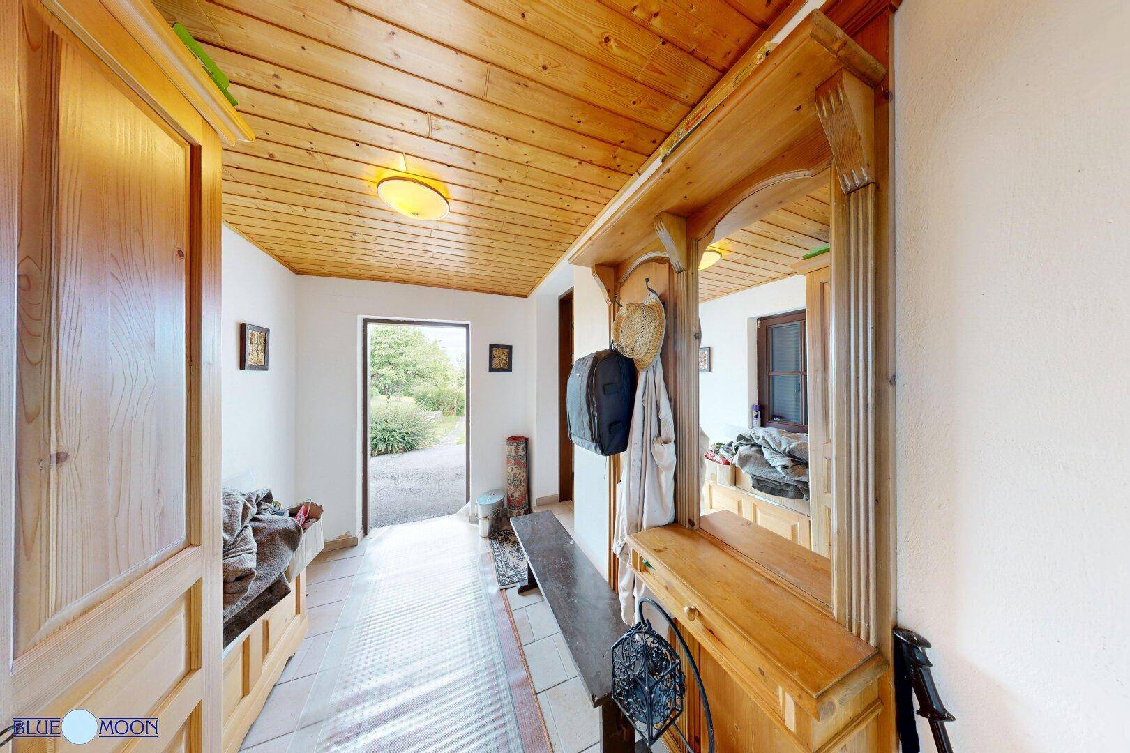 Eingangsbereich mit Holzboden, Garderobe und Zugang zum Garten.
