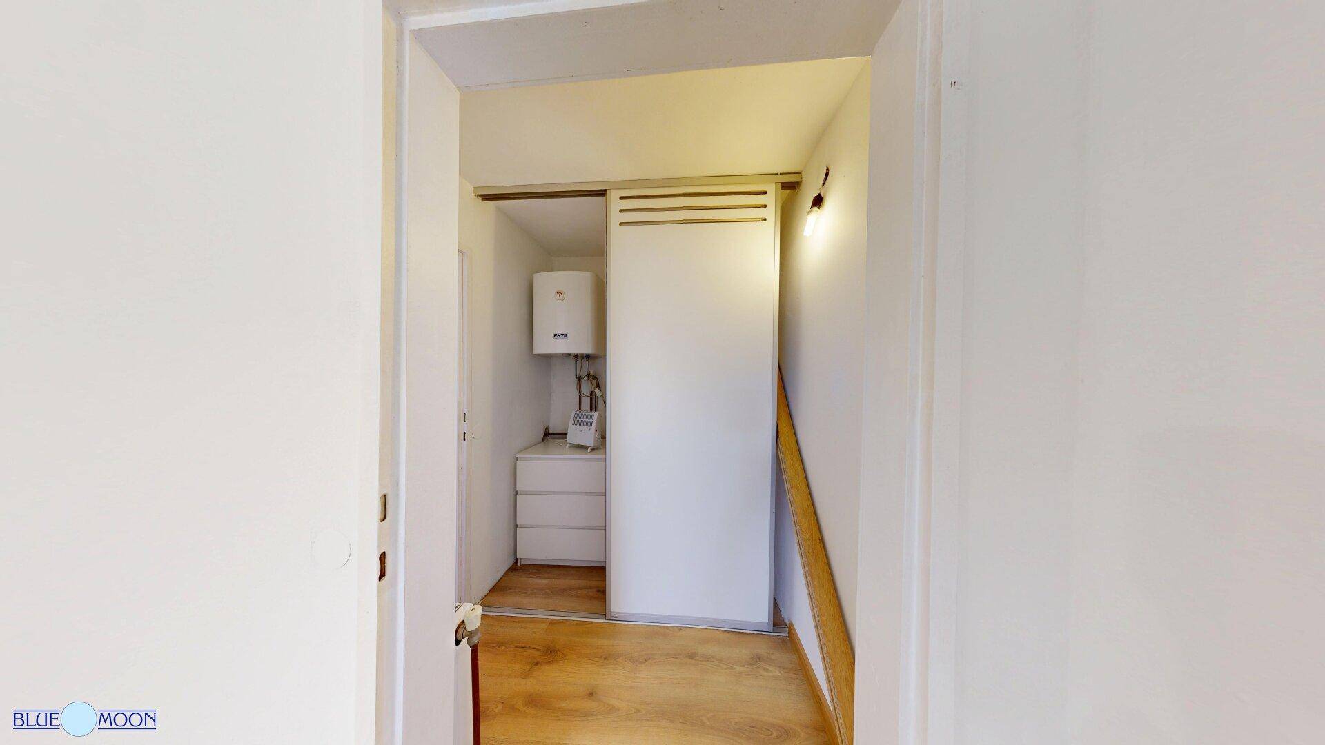 Flur mit Laminatboden und einem Wandschrank, der einen Warmwasserbereiter verbirgt.
