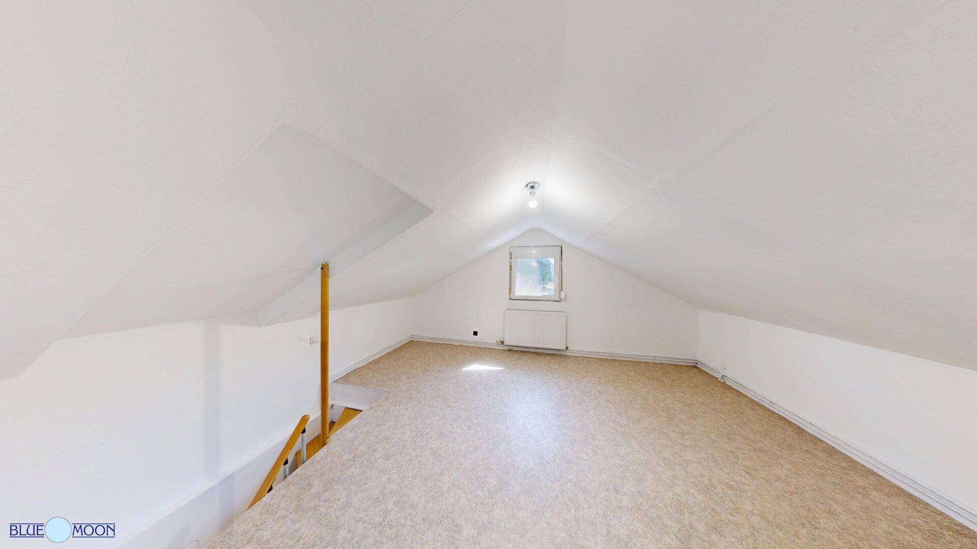 Dachbodenraum mit Fenster, schrägen Wänden und viel natürlichem Licht.