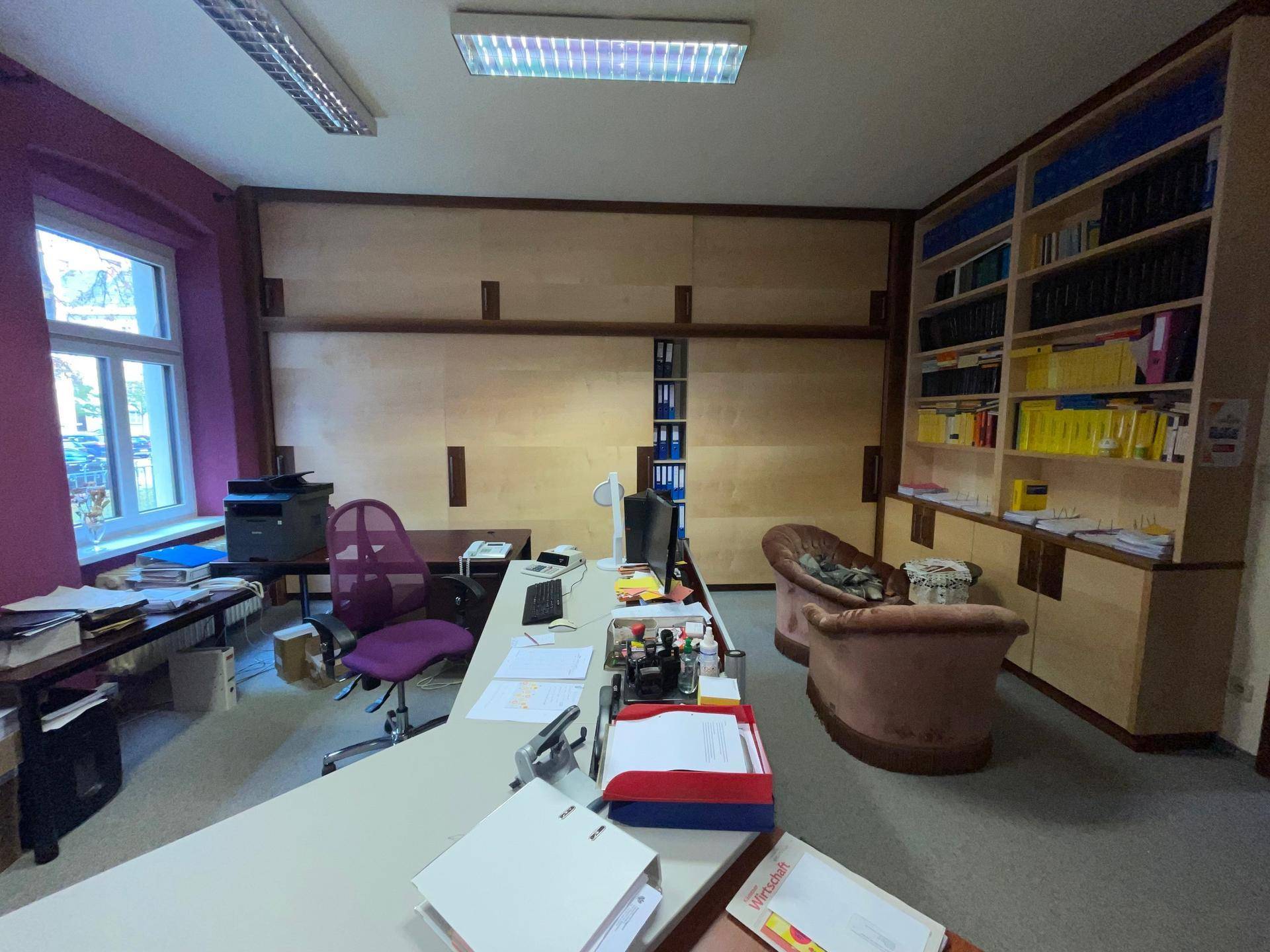 Büro mit Holzvertäfelung, Schreibtisch und bequemen Sesseln, bietet eine funktionale Arbeitsumgebung.