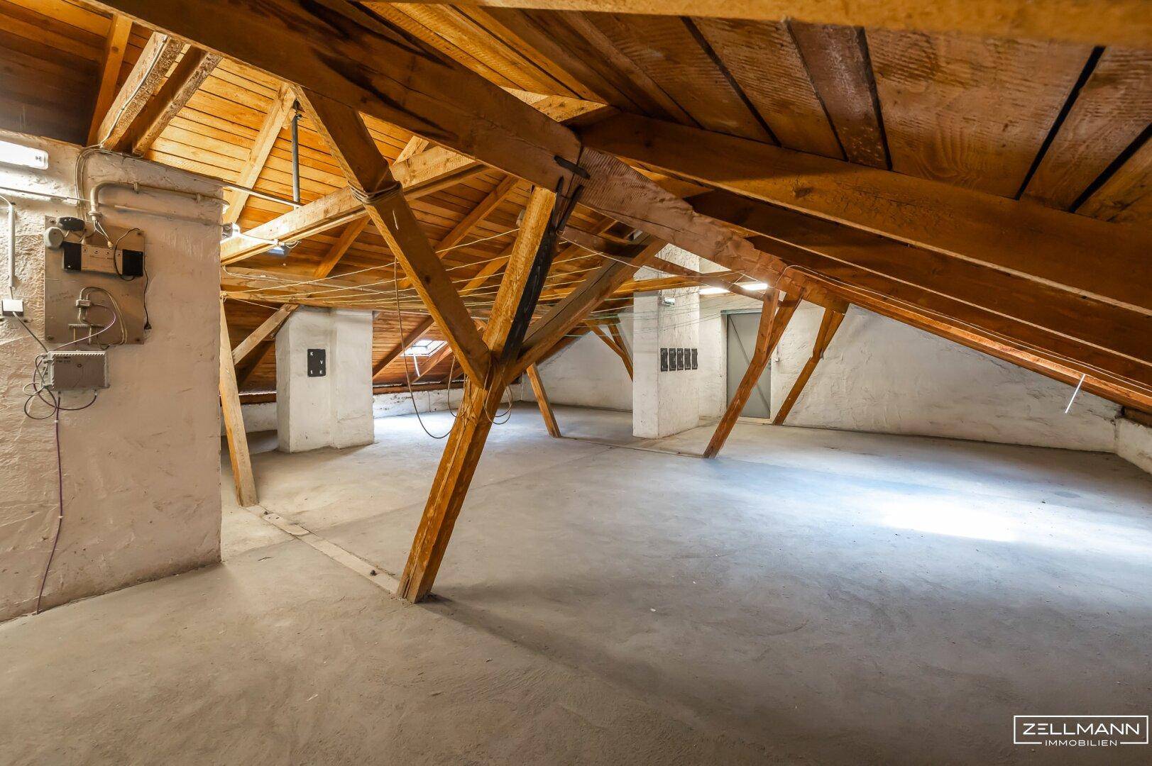 Großer Dachboden mit Holzbalken und Betonboden, ideal für zusätzlichen Stauraum oder Ausbau.