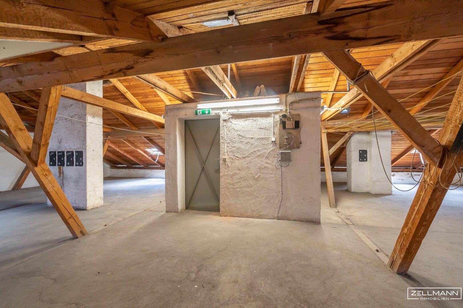 Dachboden mit freiliegenden Holzbalken und einem Aufzug, der den Zugang erleichtert.