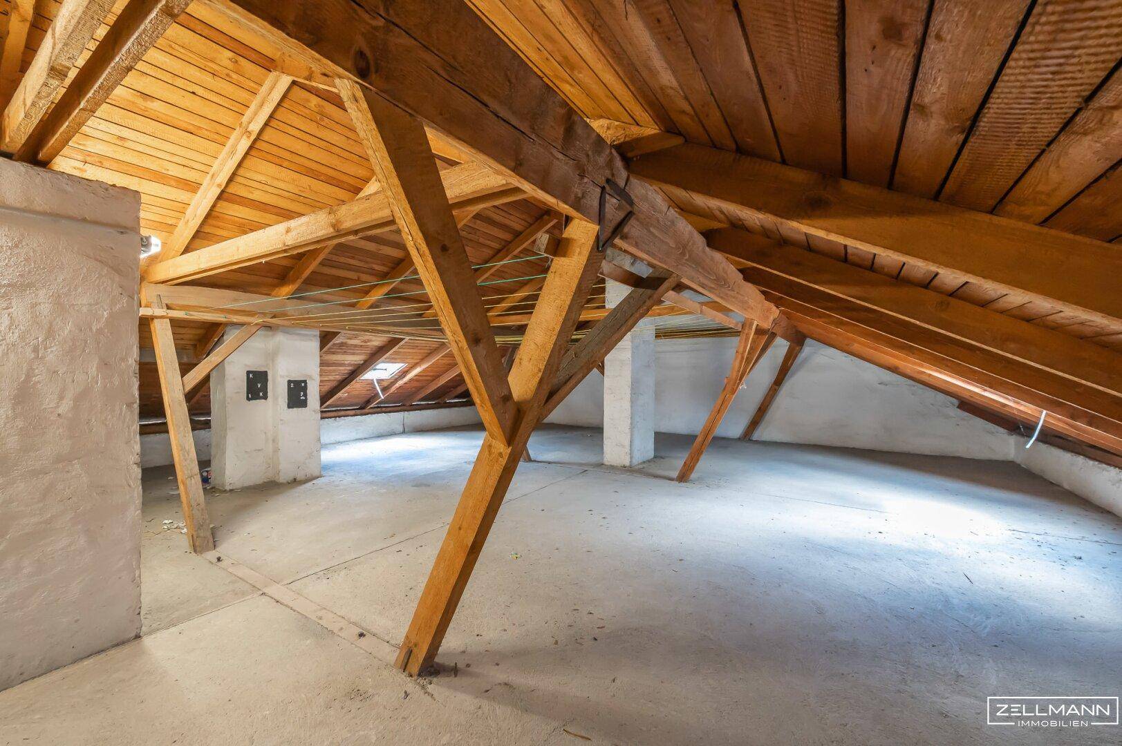 Dachboden mit sichtbarer Holzkonstruktion und schrägen Wänden, bereit für kreative Gestaltung.