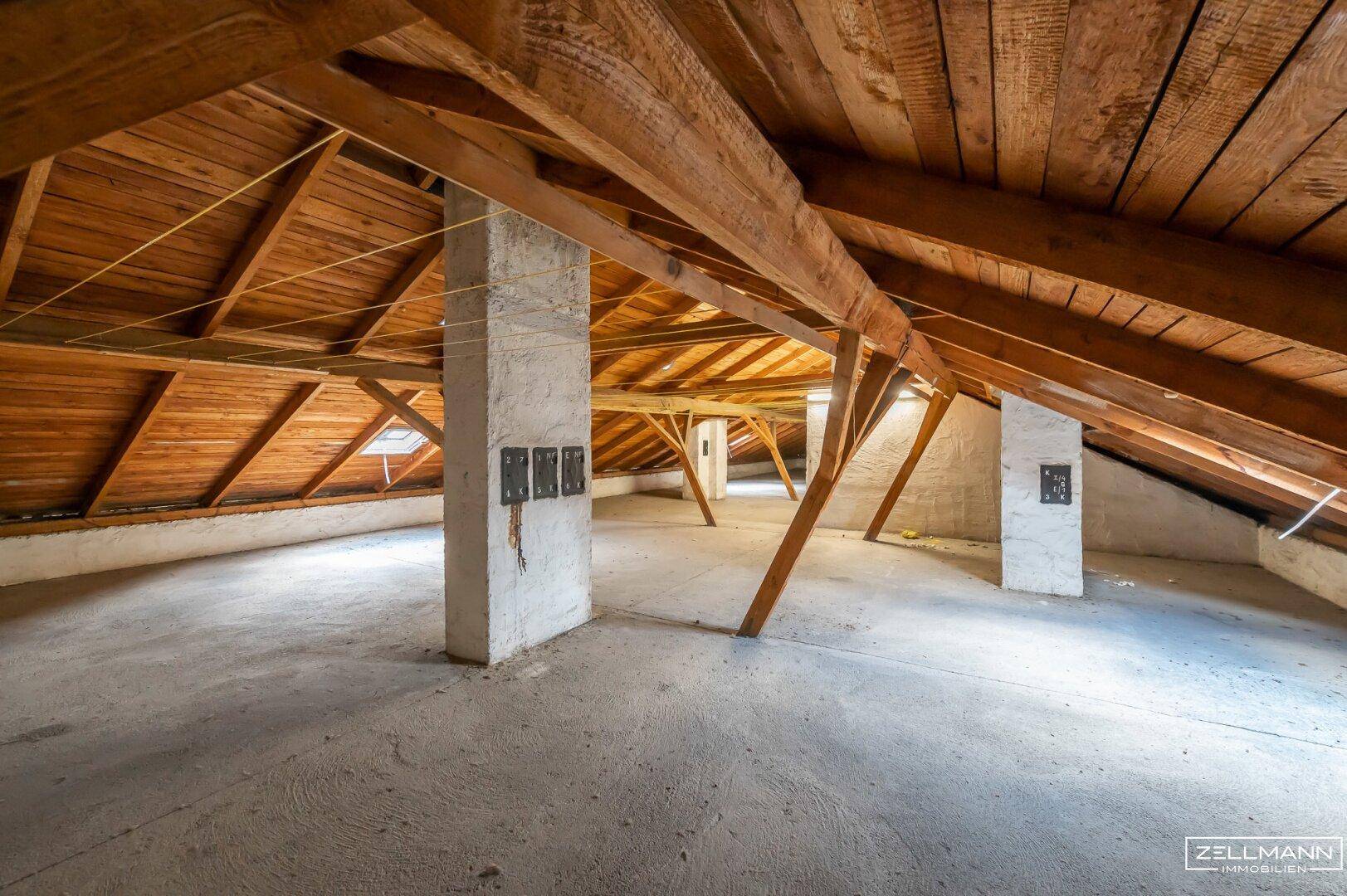 Dachboden mit massiven Holzbalken und Betonboden, bietet viel Potenzial für eine Umgestaltung.