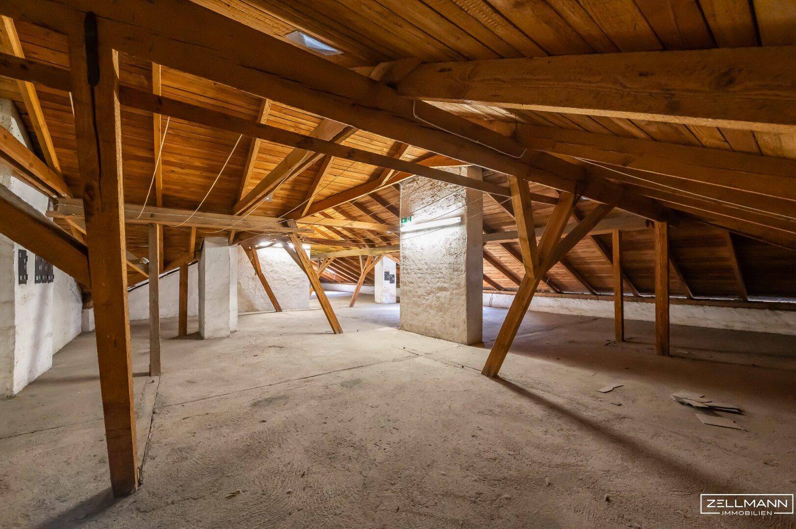 Großer Dachboden mit Holzbalken und Betonboden, ideal für zusätzlichen Stauraum oder Ausbau.