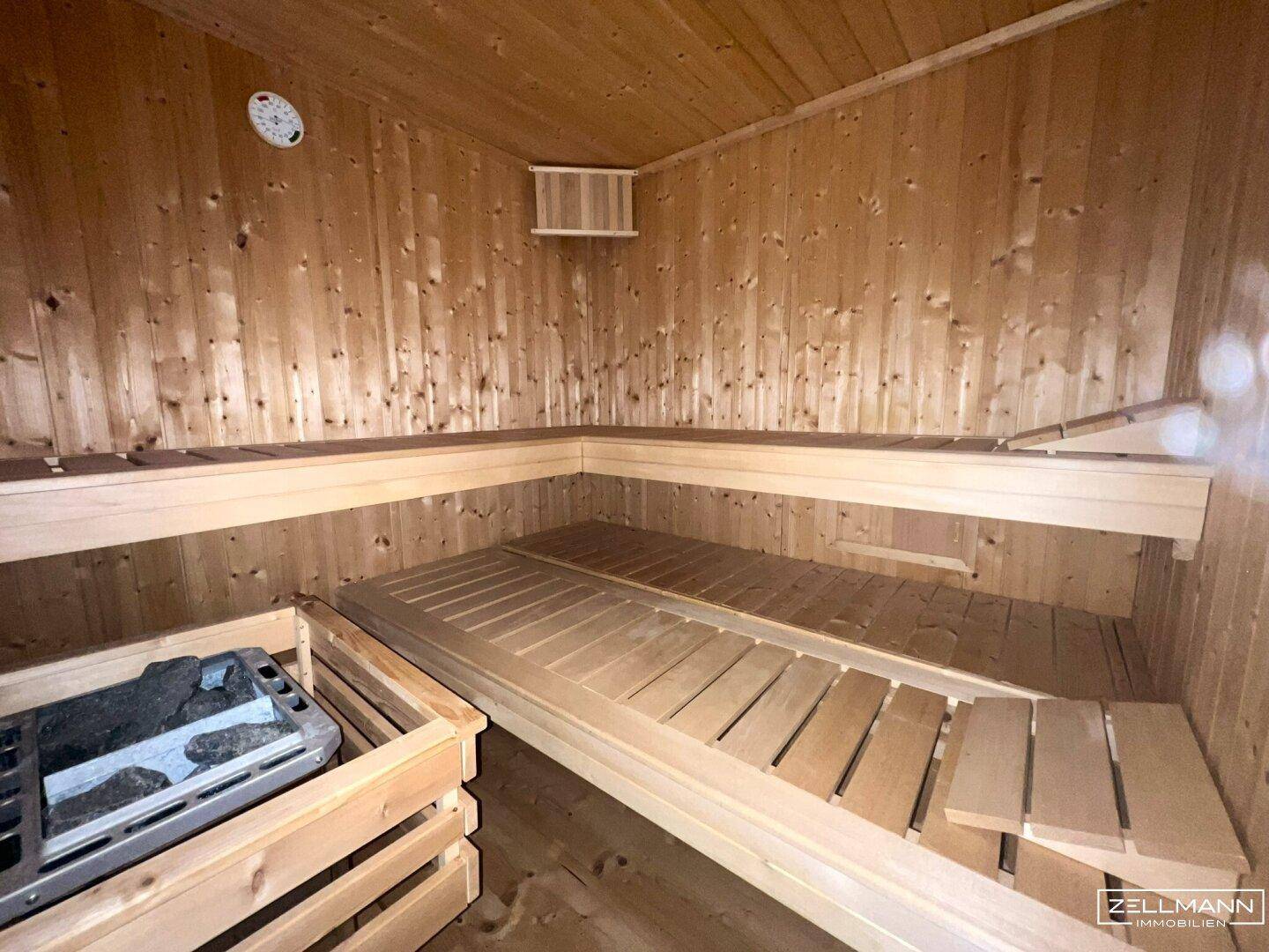 Gemütliche Holzsauna mit Bänken und Ofen, perfekt zur Entspannung nach einem langen Tag.