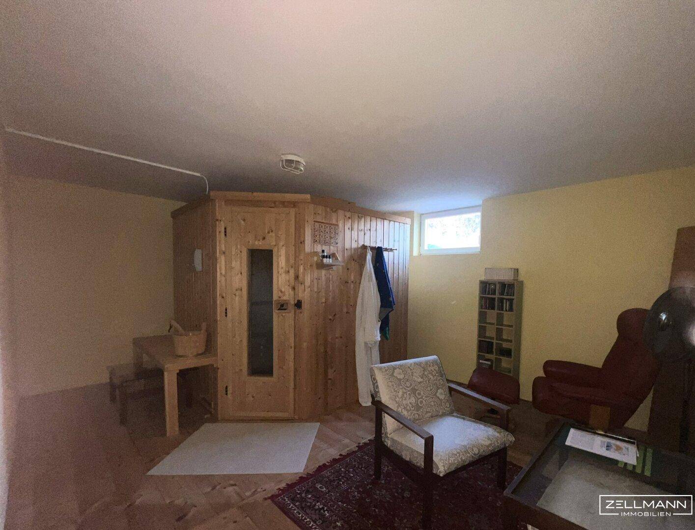 Gemütlicher Kellerraum mit integrierter Sauna und Sitzgelegenheiten für Entspannung.